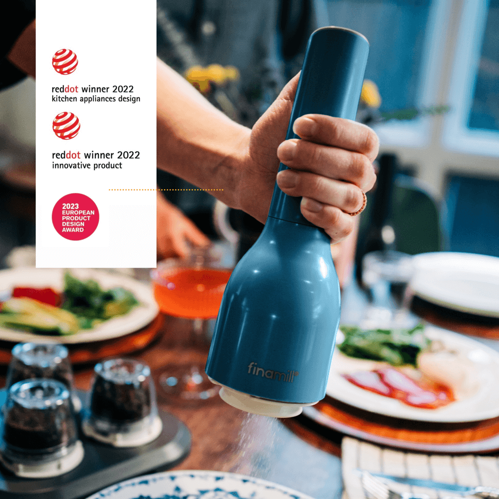 Stylish FINAMILL battery-operated grinder in Ocean Blue being used at a dinner table, showcasing award-winning design.