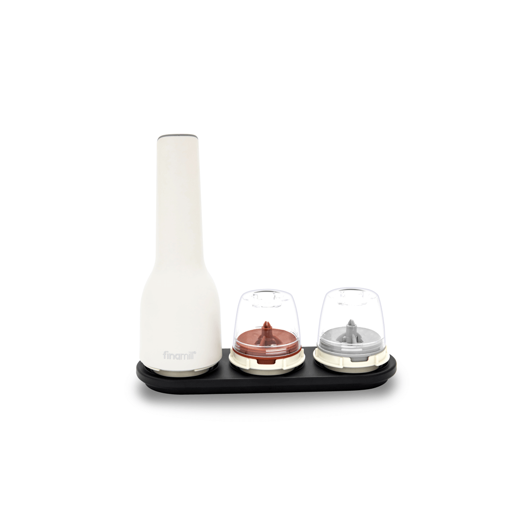 FINAMILL rechargeable grinder in soft cream color with two detachable spice containers on a black base.