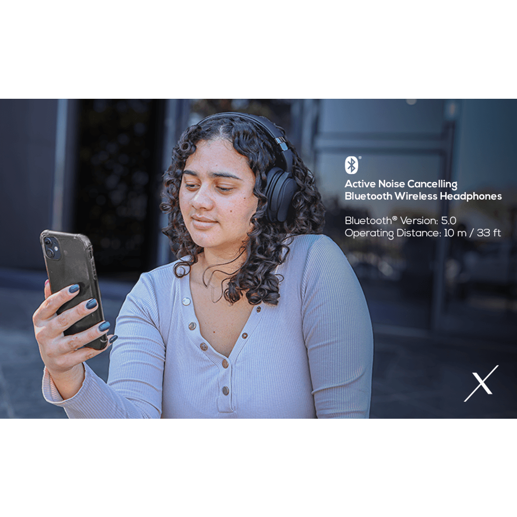Woman using VolkanoX Silenco Series Active Noise Cancelling Bluetooth headphones outdoors.
