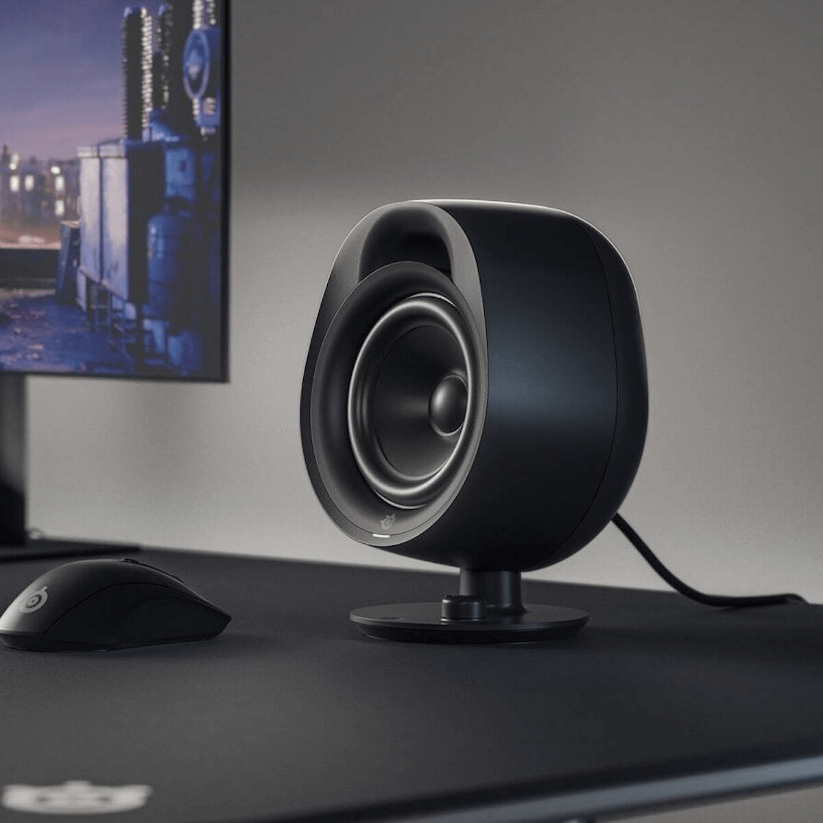 Organic audio speaker on desk with monitor and mouse, representing an engaging sound experience.