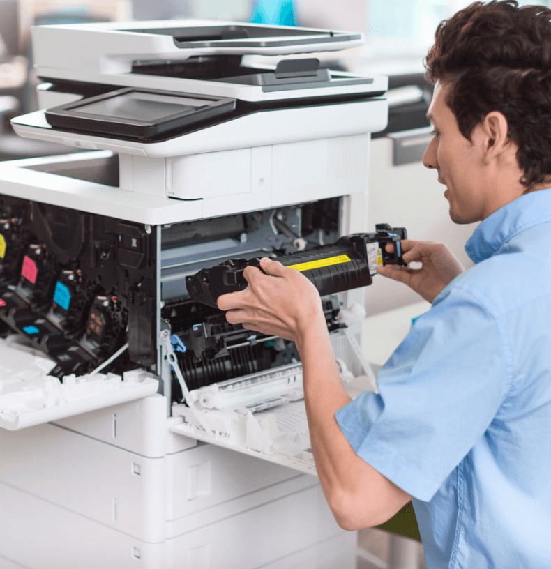 Technician replacing toner in a multifunction printer in a modern office setting.