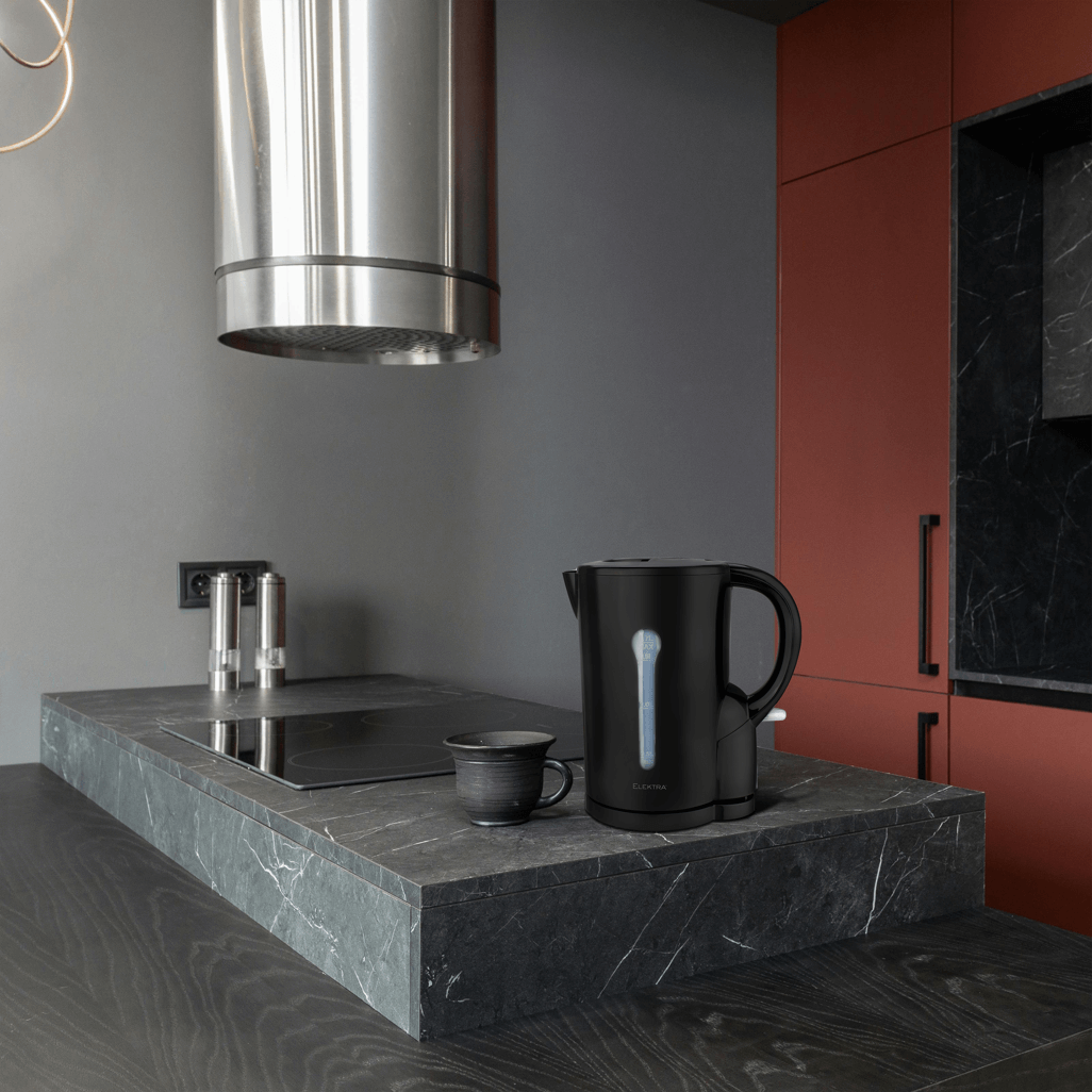 ELEKTRA 1.7L black cordless kettle on a kitchen countertop with a cup, showcasing modern design and functionality.