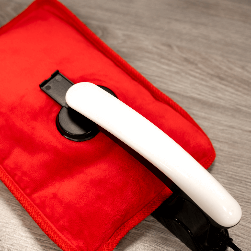 Close-up of ELEKTRA red hot water bottle featuring a white handle, perfect for warmth and comfort.