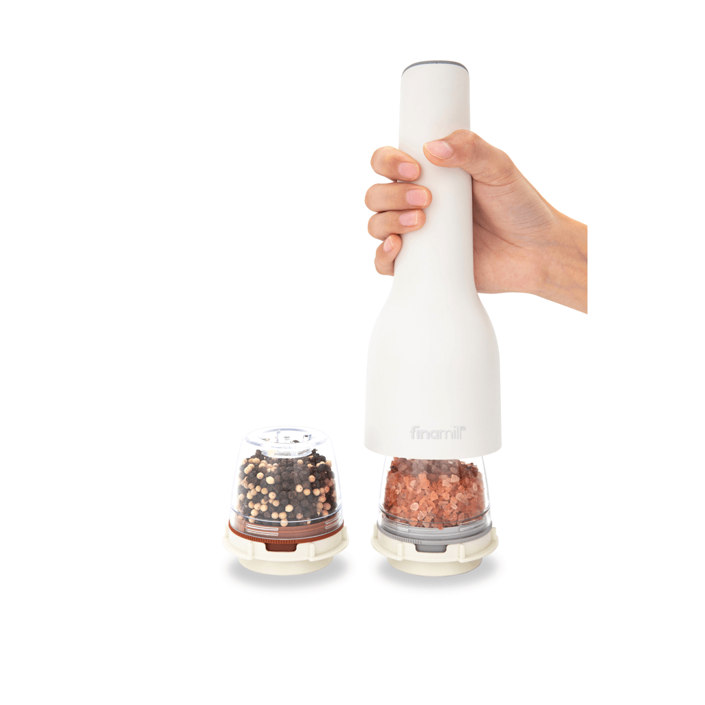 FINAMILL rechargeable grinder in soft cream with hand holding it and spice containers beside.