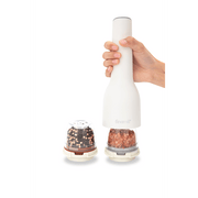 FINAMILL rechargeable grinder in soft cream with hand holding it and spice containers beside.