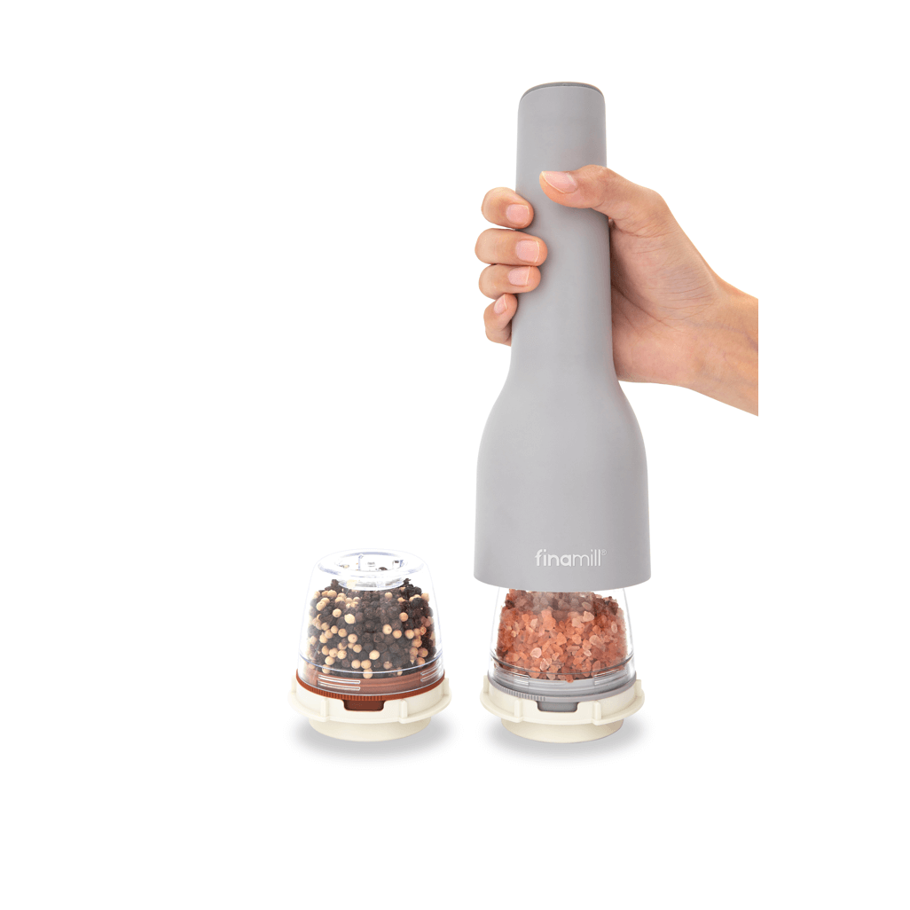FINAMILL rechargeable grinder in hand, ready to grind spices with interchangeable containers of colorful pepper and salt.
