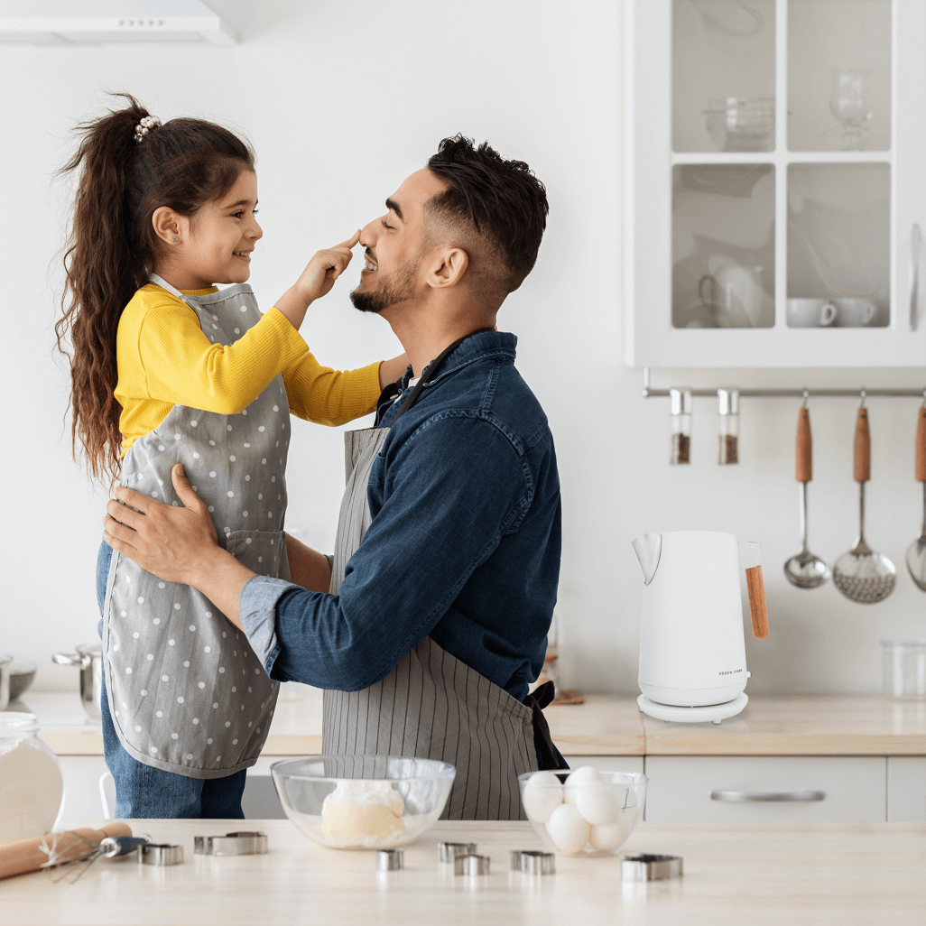 Father and daughter cooking together in a modern kitchen with a Boden Stark Anson White kettle on the counter.