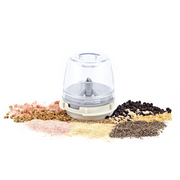 FinaPod Pro Plus spice grinder surrounded by various spices including pink salt, black pepper, and coriander.