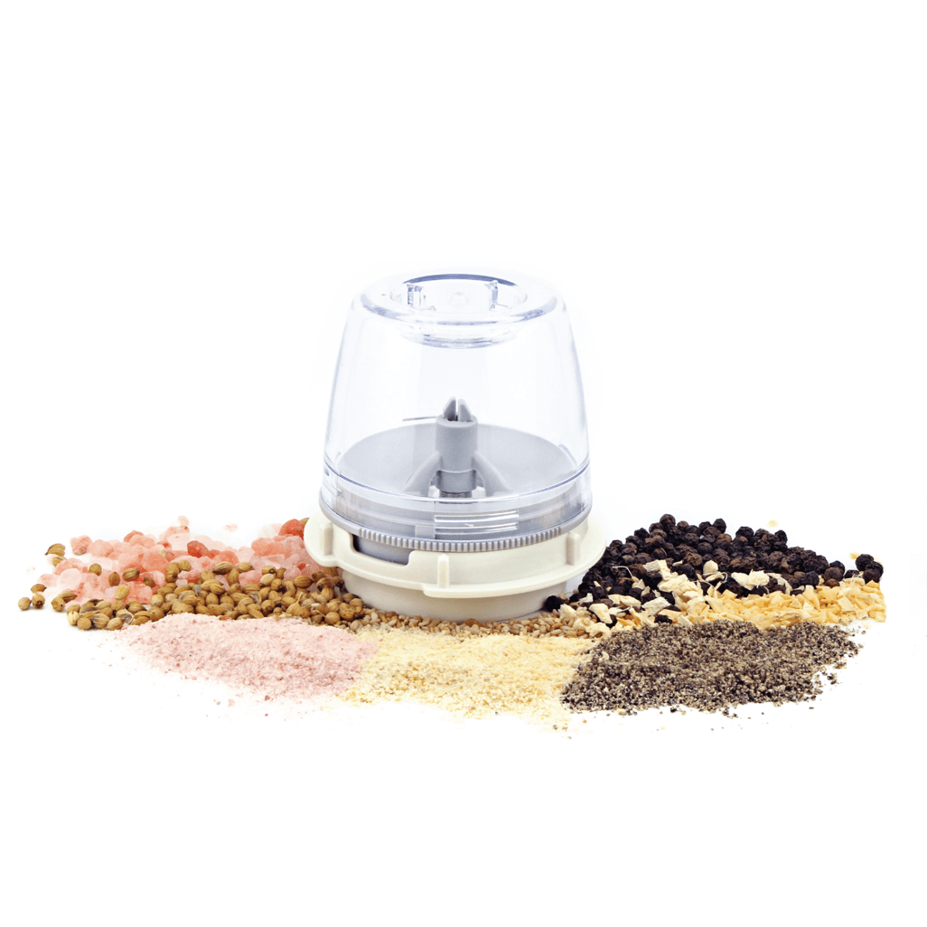 FinaPod Pro Plus spice grinder surrounded by various spices including pink salt, black pepper, and coriander.