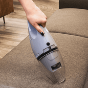 Boden Stark Handheld Vacuum Cleaner in use on a couch surface, showcasing its versatile cleaning capability.