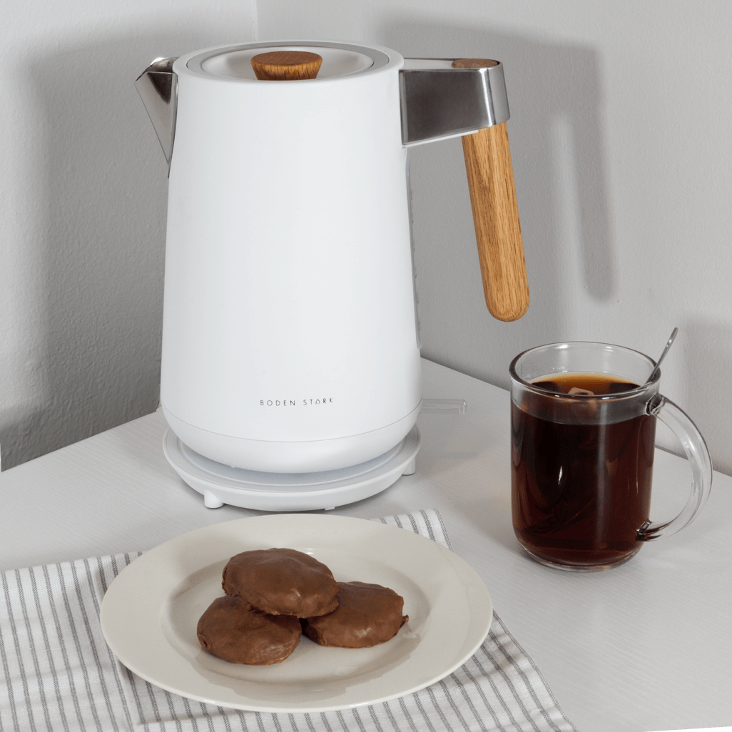 Boden Stark Anson Collection 1.7L 2000W stainless steel kettle in white with tea and cookies on a table.