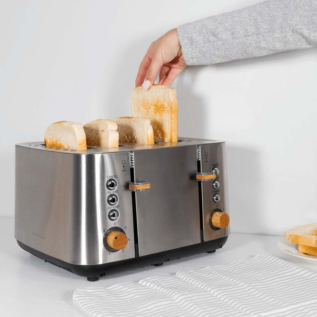 Boden Stark Anson Collection 4 Slice SS Toaster with toast being added, showcasing its sleek design and functionality.