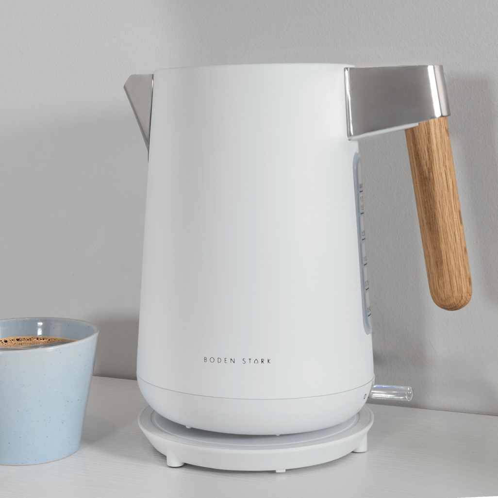 Boden Stark Anson Collection 1.7L 2000W stainless steel kettle in white with wooden handle next to a blue cup.