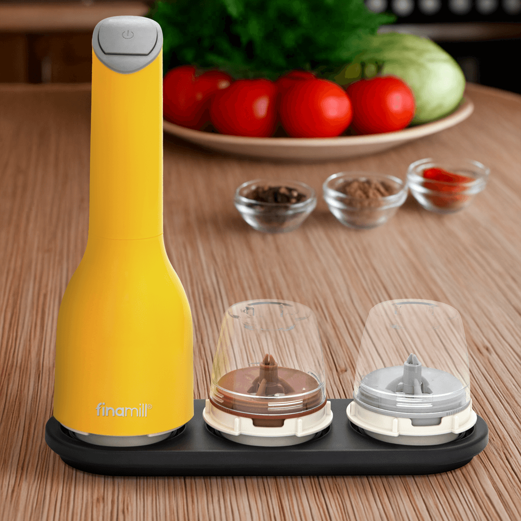 FINAMILL battery operated grinder in Canary with spice jars on a wooden countertop, showcasing design and functionality.