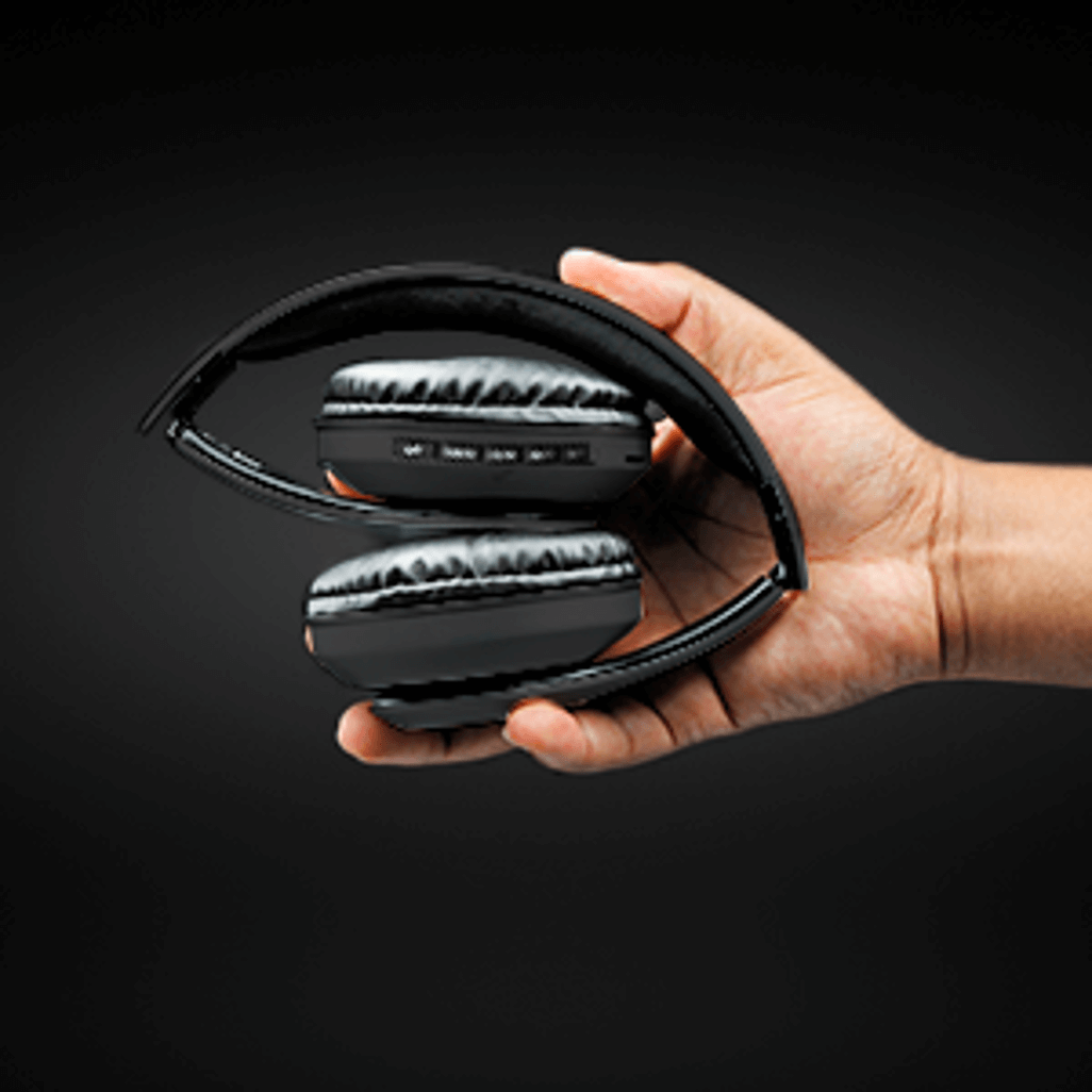 Hand holding the compact Volkano Impulse Series Bluetooth headphones in black.
