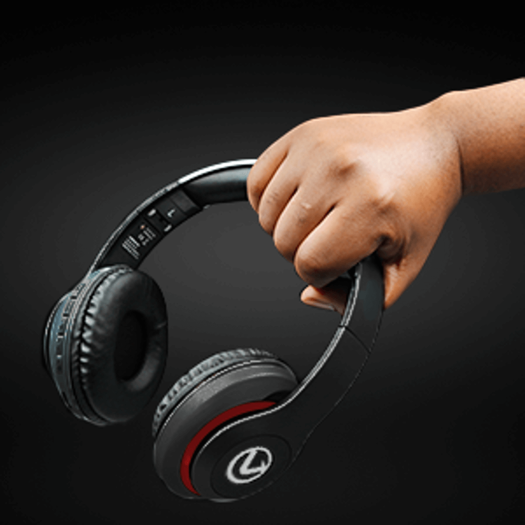 Hand holding black Volkano Impulse Series Bluetooth headphones, showcasing their modern design and comfort.