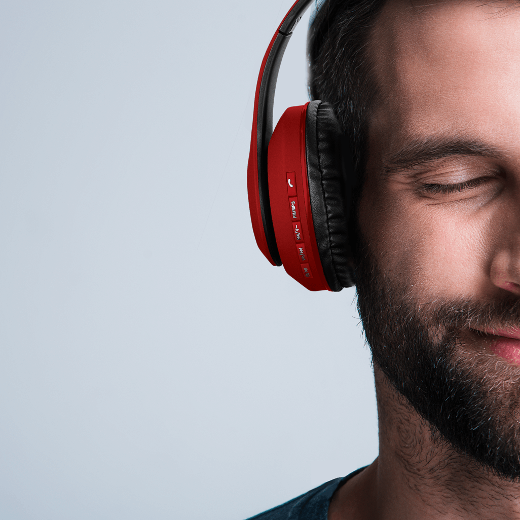 Close-up of a man enjoying music with Volkano Impulse Series Bluetooth Headphones in red, emphasizing organic sound experience.