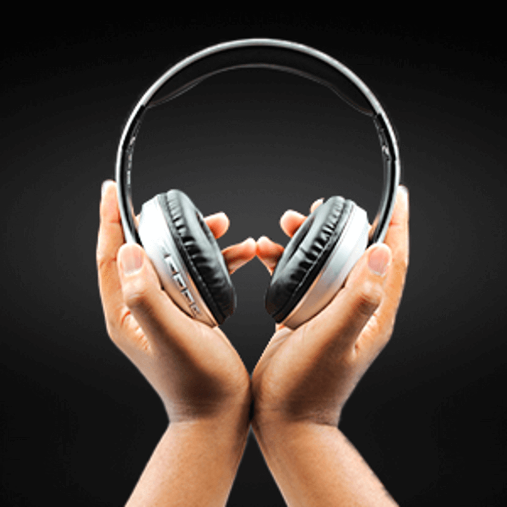 Hands holding Volkano Impulse Series Bluetooth Headphones in white against a black background.