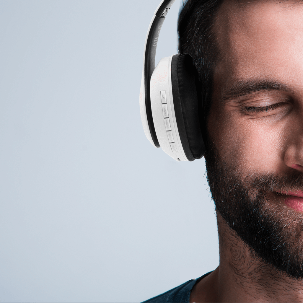 Man enjoying music with Volkano Impulse Series Bluetooth Headphones in white, featuring an organic design.
