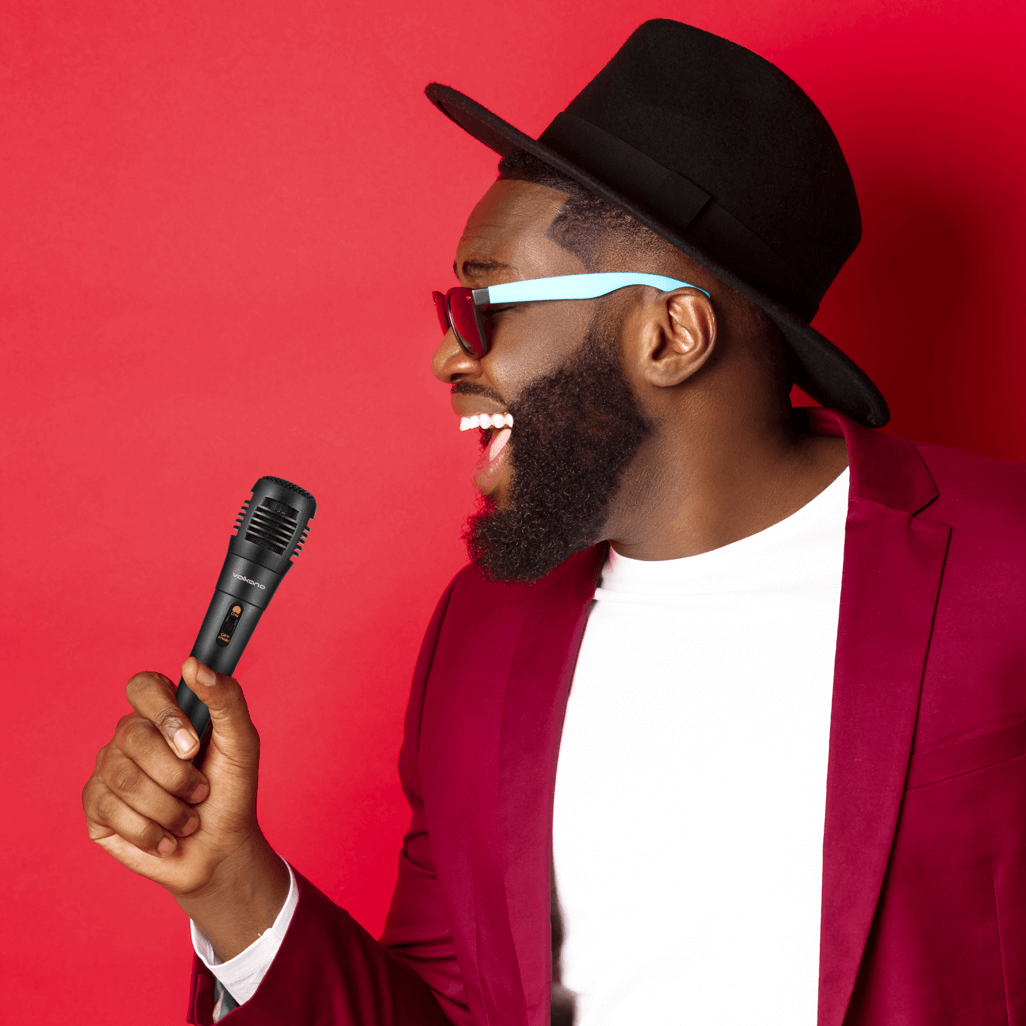 Exciting man holding a Volkano Vocal series ABS wired microphone in black, ready to perform with style!
