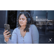 Woman using VolkanoX Silenco Series Active Noise Cancelling Bluetooth headphones outdoors.